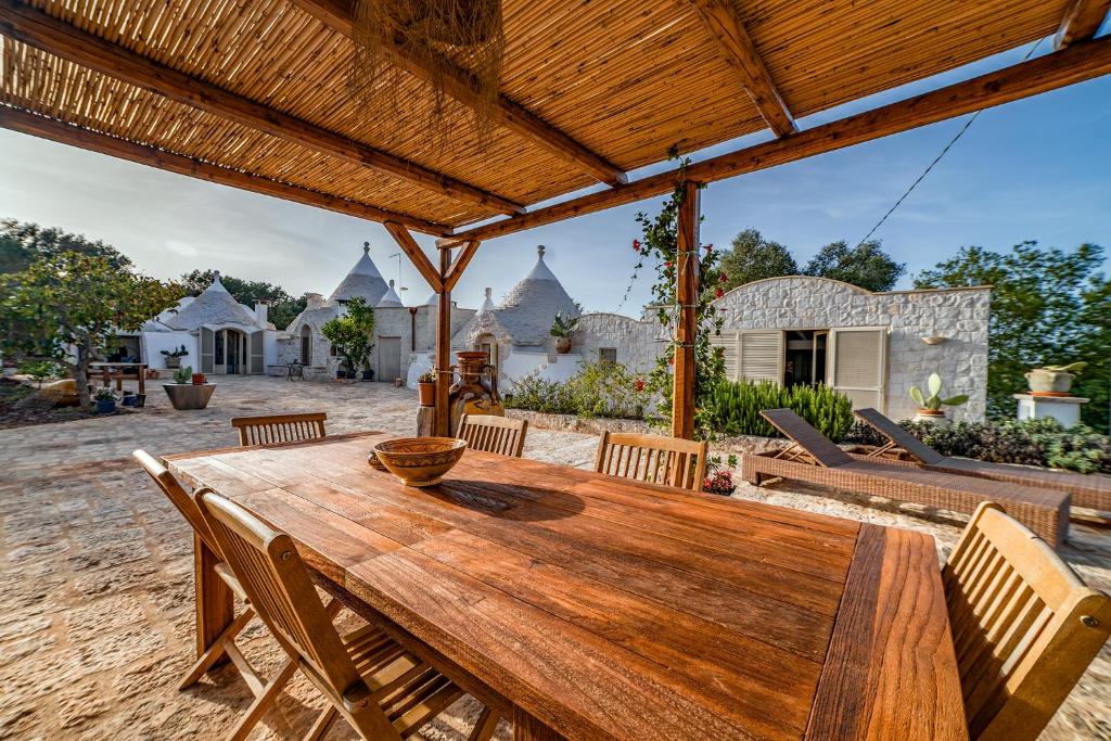 une table et des chaises en bois sur une terrasse dans l'établissement Trulli Magalò, à Ceglie Messapica