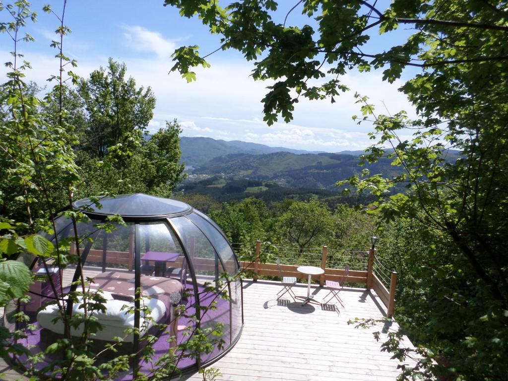 - un dôme en verre sur une terrasse avec vue sur les montagnes dans l'établissement Nuits D'y Cîmes : Nuit Insolite Bulle, SPA, à Jaunac
