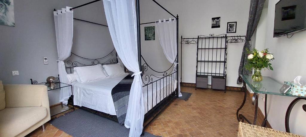une chambre avec un lit à baldaquin avec des rideaux blancs dans l'établissement Riad Ramzi, à Marrakech