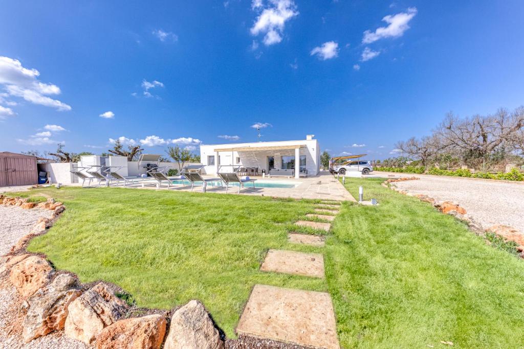 une cour avec un mur en pierre et une maison dans l'établissement Villa Cento Ulivi, à Ugento