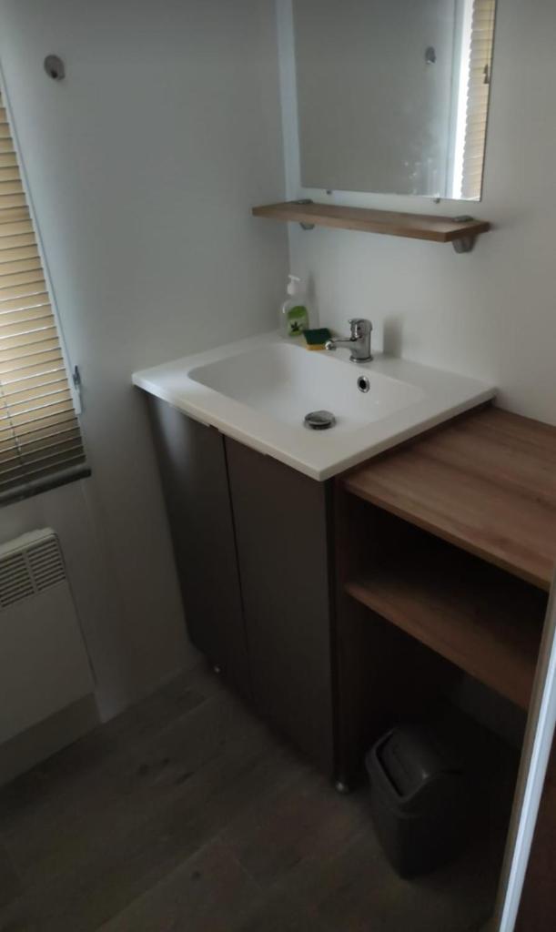 une salle de bain avec un lavabo blanc et un miroir dans l'établissement Camping des Dunes de Contis mobilhome 3ch,, à Saint-Julien-en-Born