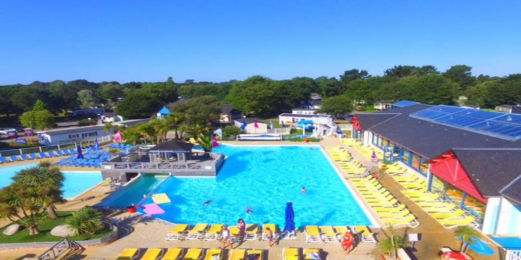 une vue aérienne d'une piscine dans un complexe hôtelier dans l'établissement MOBIL HOME 2 CHAMBRES 1 SDB - DOMAINE DE KERLANN, à Pont-Aven