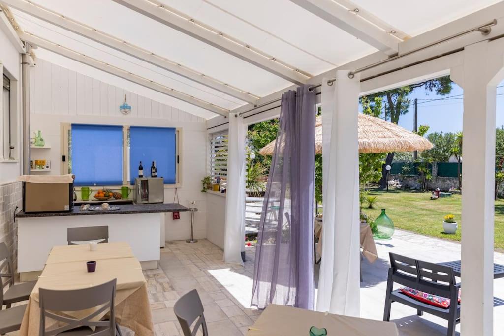 un patio avec une table, des chaises et un parasol dans l'établissement Villa Soleanna Residence, à Vieste
