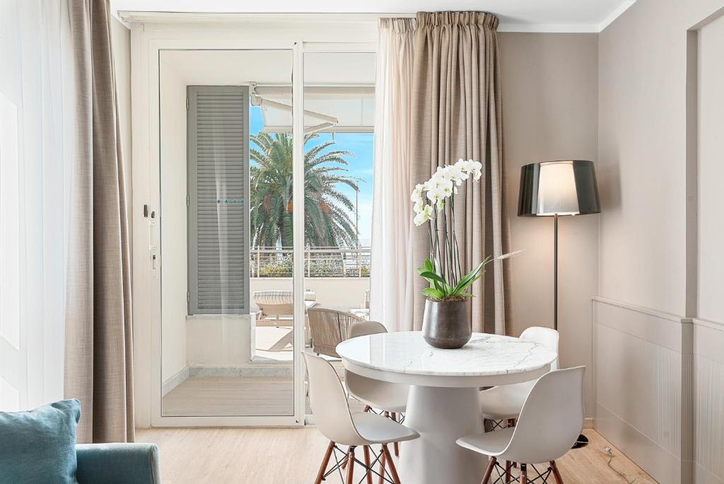 une salle à manger blanche avec une table et des chaises blanches dans l'établissement Hotel Excelsior, à Marina di Massa 124 autres photos