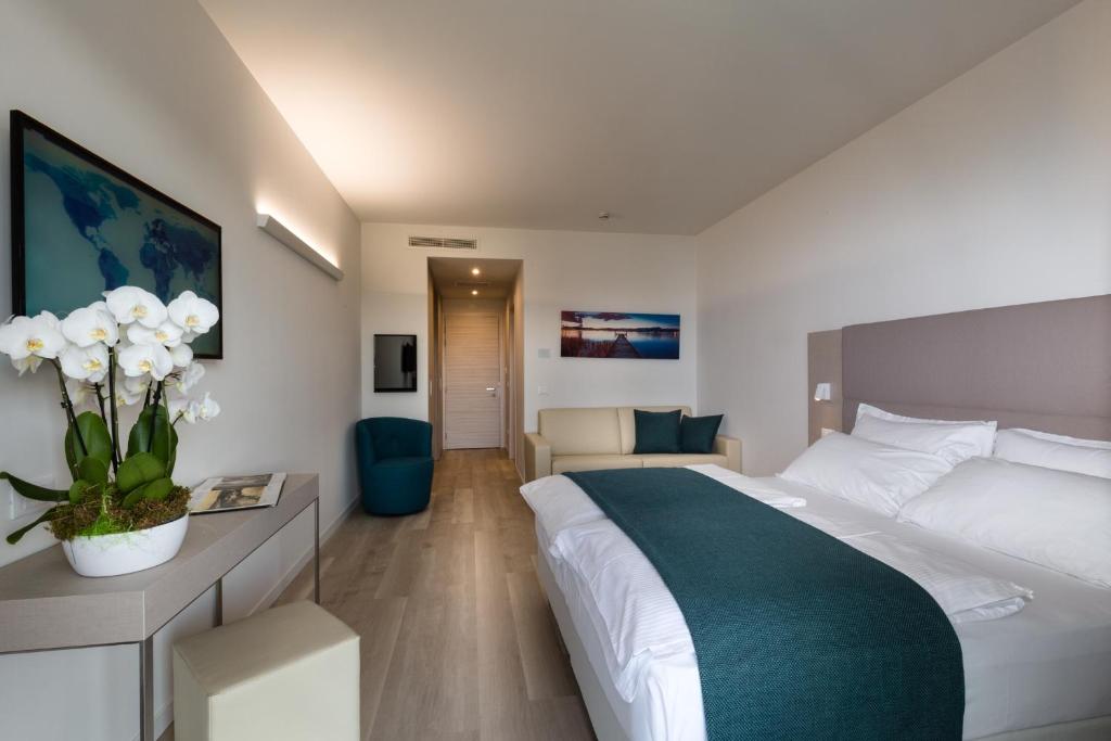une chambre d'hôtel avec un grand lit et un canapé dans l'établissement Hotel Europa, à Sirmione