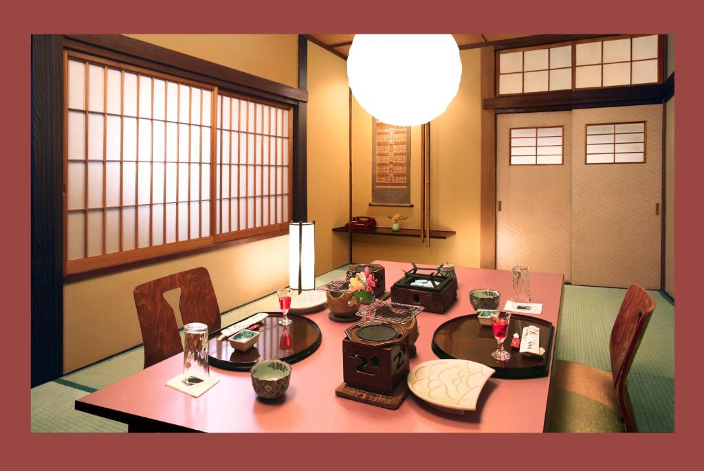 d'une salle à manger avec une table, des chaises et de l'aupuncture. dans l'établissement Ekinariya Ryokan, à Kusatsu