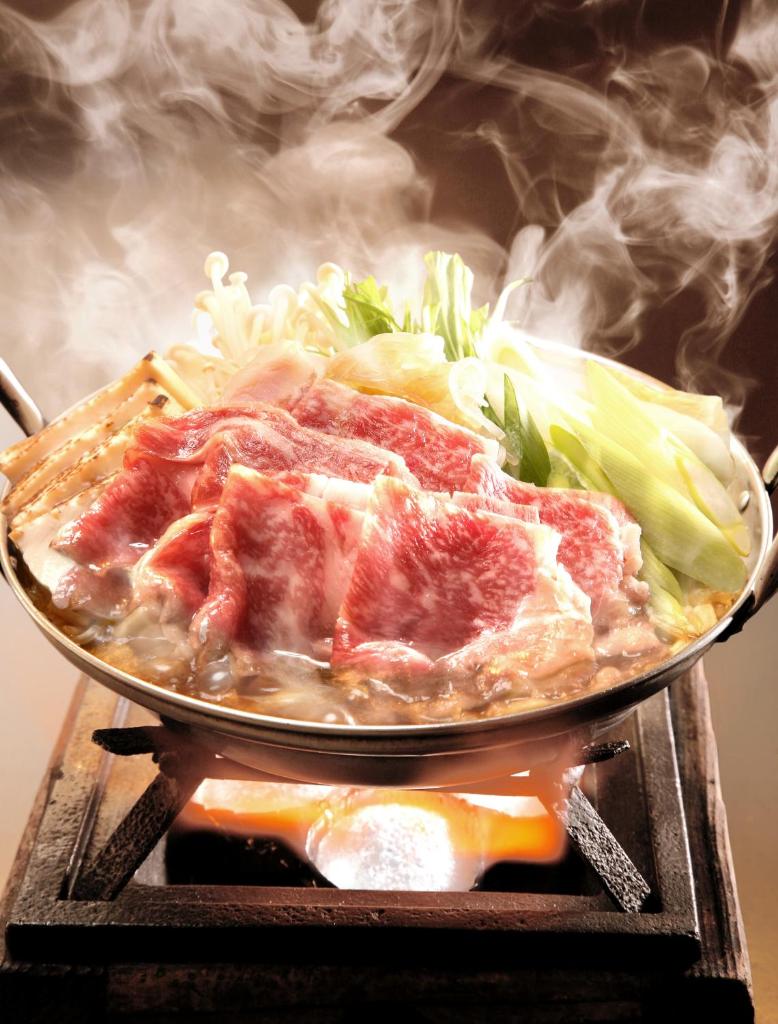 un plat avec de la viande et des légumes sur un grill dans l'établissement Ekinariya Ryokan, à Kusatsu