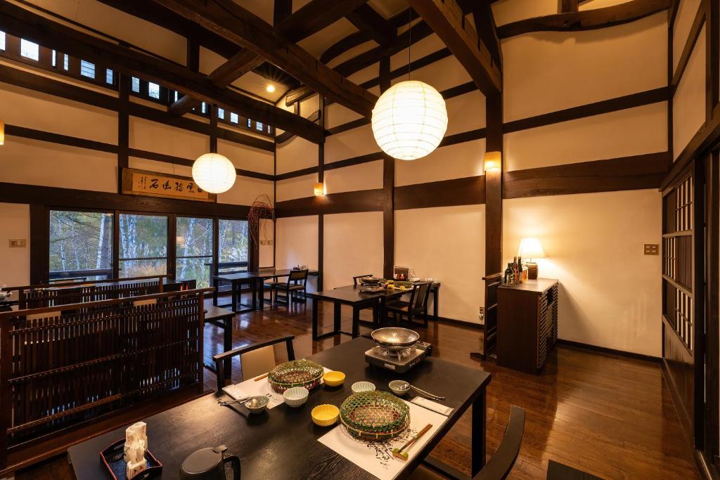 une salle à manger avec des tables, des chaises et des lumières dans l'établissement Konashi No Yu Sasaya, à Matsumoto