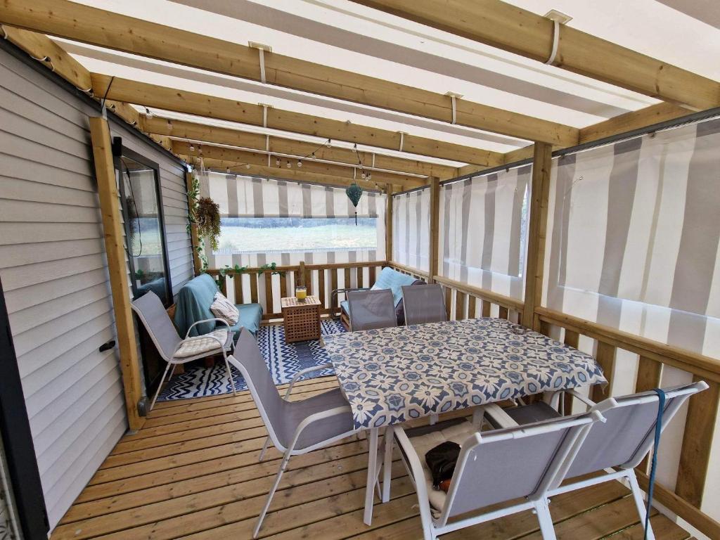 un patio avec une table et des chaises sur une terrasse dans l'établissement Mobil Home tout confort, à Saint-Hilaire-de-Riez