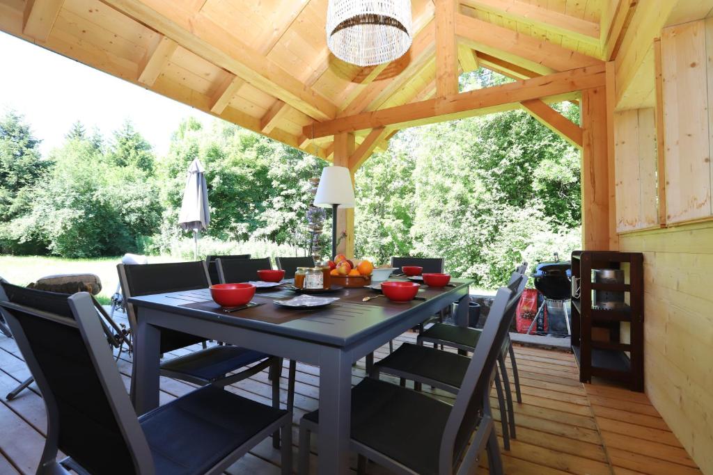une table et des chaises sur une terrasse avec un plafond en bois dans l'établissement Chalet de l’Alpette, à Valloire