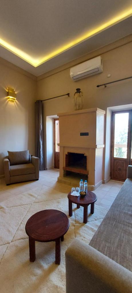 un salon avec un canapé et une cheminée dans l'établissement riad sbai palace, à M'Hamid El Ghizlane