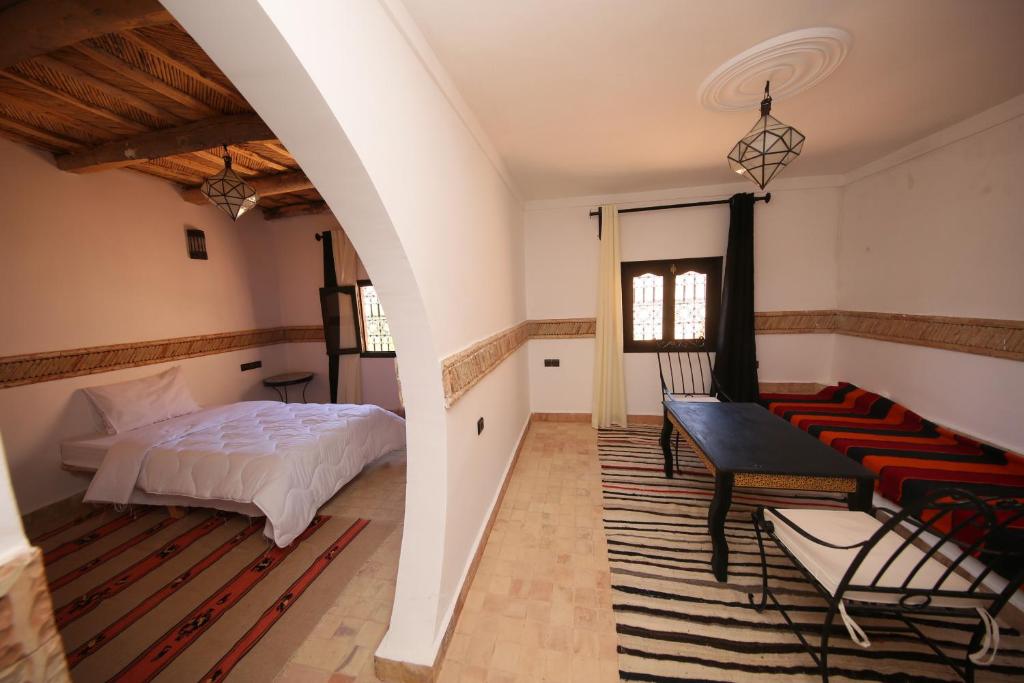 une chambre avec un lit, une table et un canapé dans l'établissement Riad Villa Dades, à Boumalne