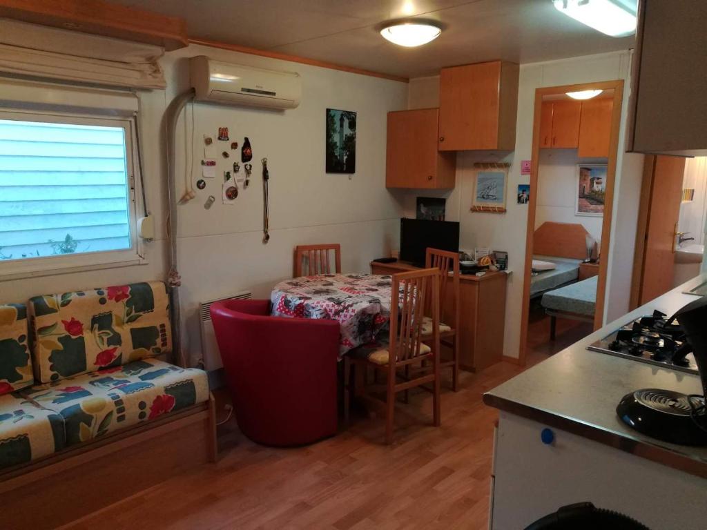 une cuisine et un salon avec une table et une salle à manger dans l'établissement Mobil-Home 54 au Parc Résidentiel de la Plage - 4 personnes, à Gujan-Mestras