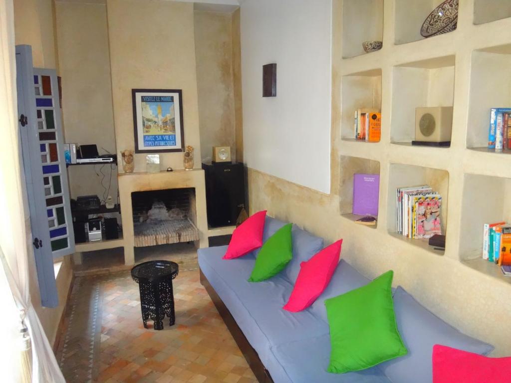 - un salon doté d'un canapé bleu avec des oreillers rouges et verts dans l'établissement Riad Bel Haj, à Marrakech