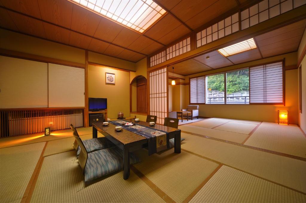 - une chambre avec une table et un canapé dans l'établissement Suzukiya Ryokan, à Shiroishi