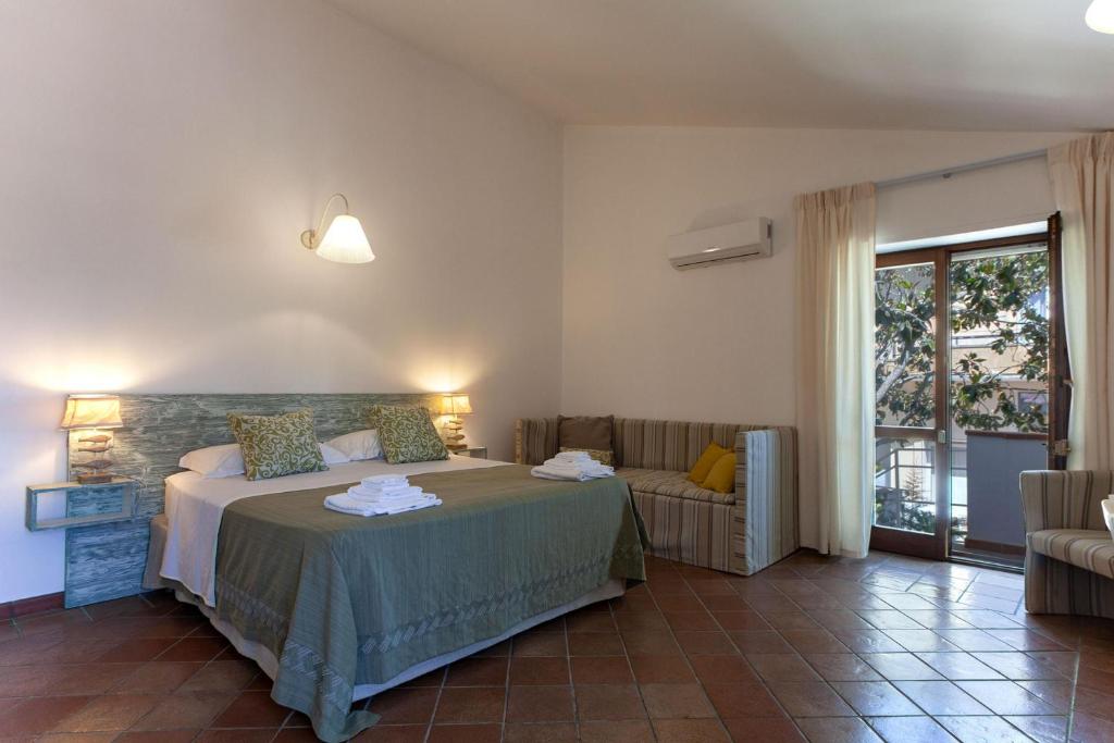une chambre avec un lit, un canapé et une fenêtre dans l'établissement Villa Nice Dream With Pool And Terrace - Happy Rentals, à Neviano