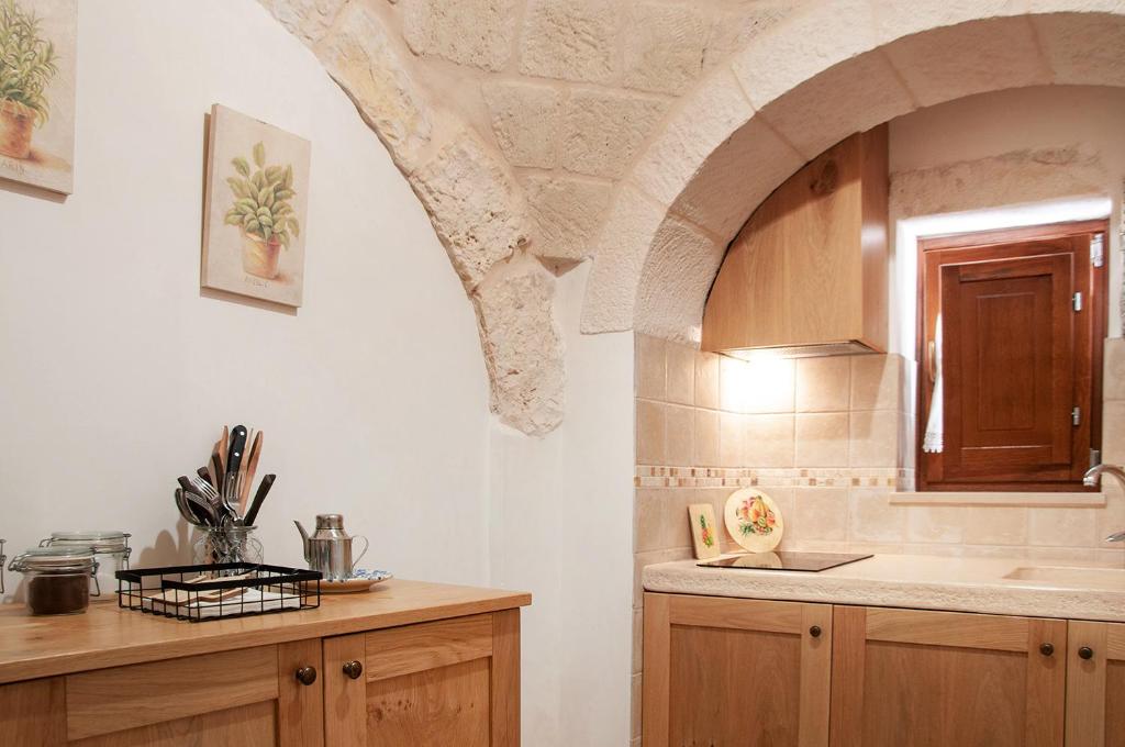 une cuisine avec un évier et un plan de travail dans l'établissement Trulli Loco, à Locorotondo
