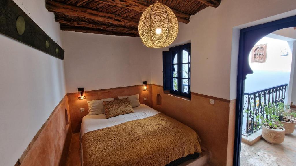une chambre avec un lit dans une pièce avec une fenêtre dans l'établissement DAR DAREK FAMILY, à Essaouira