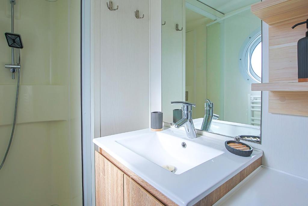 une salle de bain avec un lavabo et une douche dans l'établissement New - Mobil home tout équipé, à Saint-Jean-de-Monts
