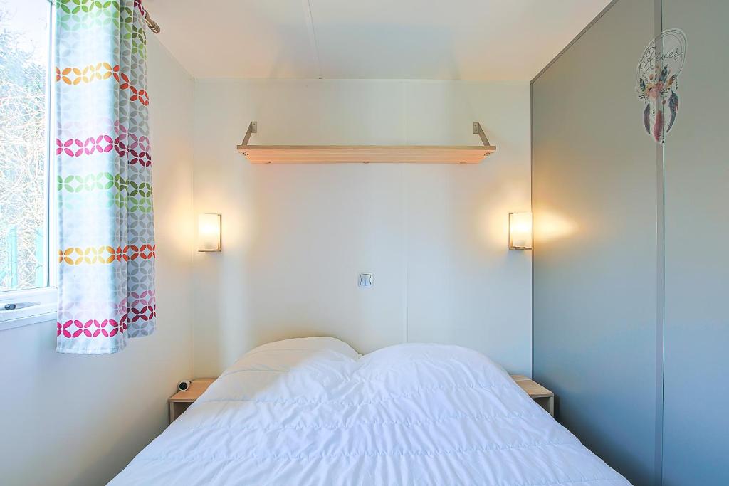 une petite chambre avec un lit blanc et une fenêtre dans l'établissement New - Mobil home tout équipé, à Saint-Jean-de-Monts