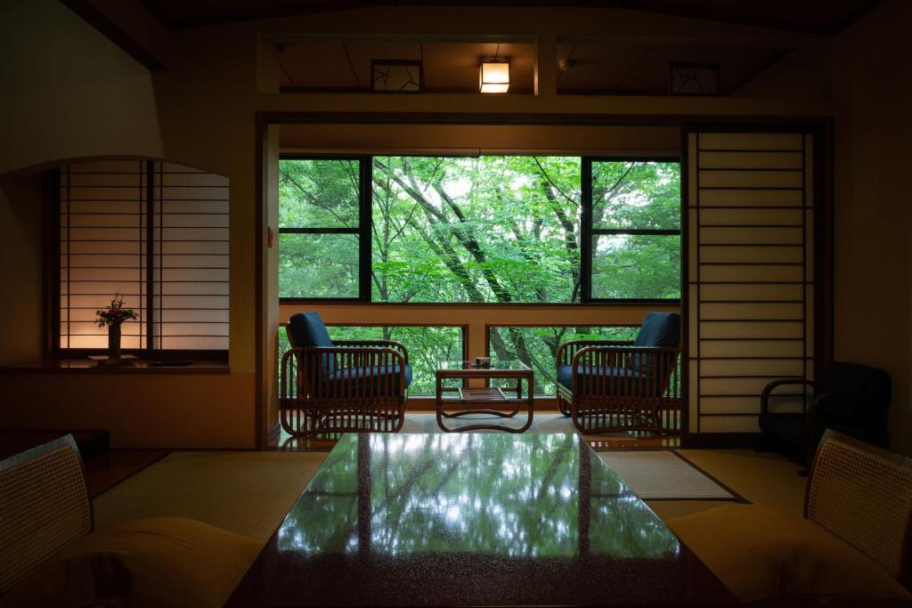 une chambre avec des chaises et une table devant une fenêtre dans l'établissement Sanso Tensui, à Hita