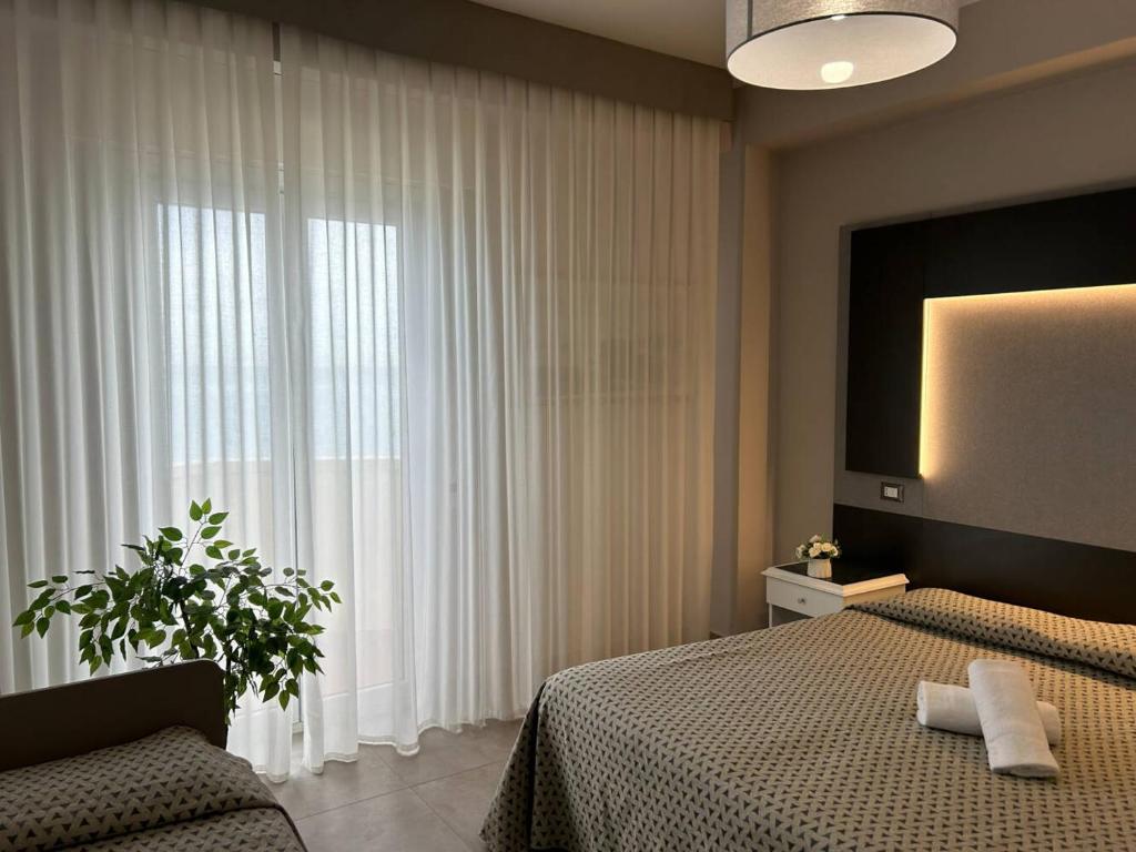 une chambre avec un lit et une grande fenêtre dans l'établissement Grand Hotel Montesilvano, à Montesilvano 53 autres photos