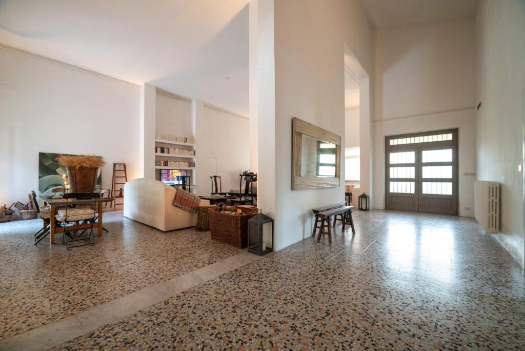 - un salon aux murs blancs avec une table et des chaises dans l'établissement La Scuola, Luxueuse villa avec piscine privée, à San Casciano dei Bagni