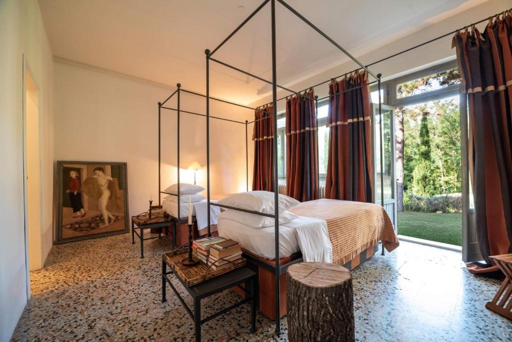 - une chambre avec un lit à baldaquin et une grande fenêtre dans l'établissement La Scuola, Luxueuse villa avec piscine privée, à San Casciano dei Bagni 12 autres photos