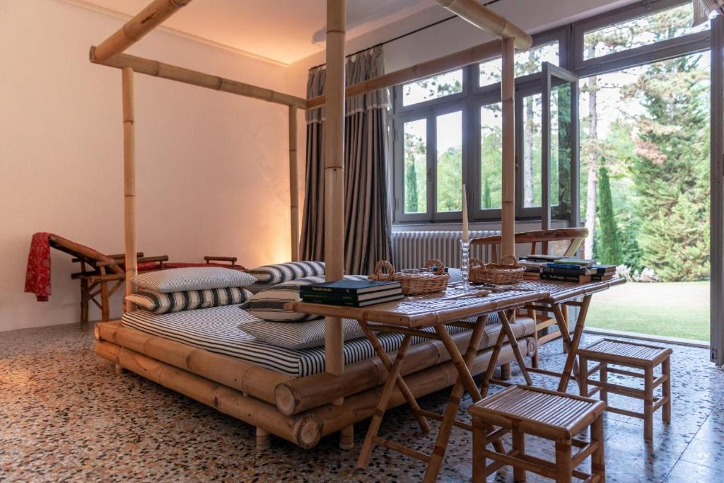 une chambre avec un lit et une table avec des chaises dans l'établissement La Scuola, Luxueuse villa avec piscine privée, à San Casciano dei Bagni