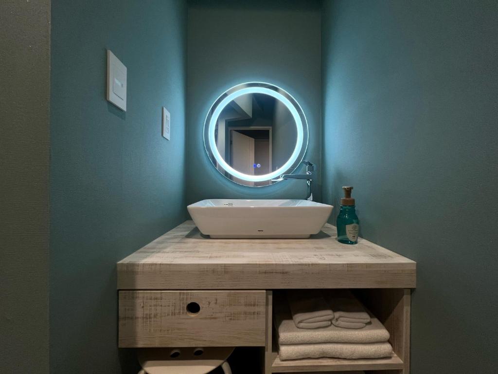 une salle de bain avec un lavabo et un miroir dans l'établissement Hotel 螢月ｰhozukiｰ Adult Only, à Sendai