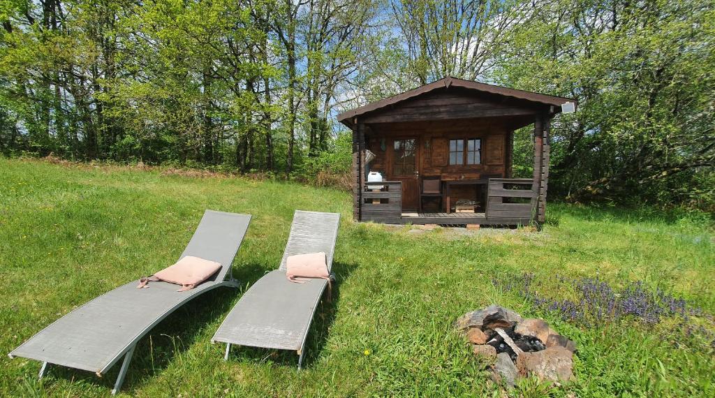 deux bancs assis dans l'herbe à côté d'un belvédère dans l'établissement wooden cabin in nature, à Troche