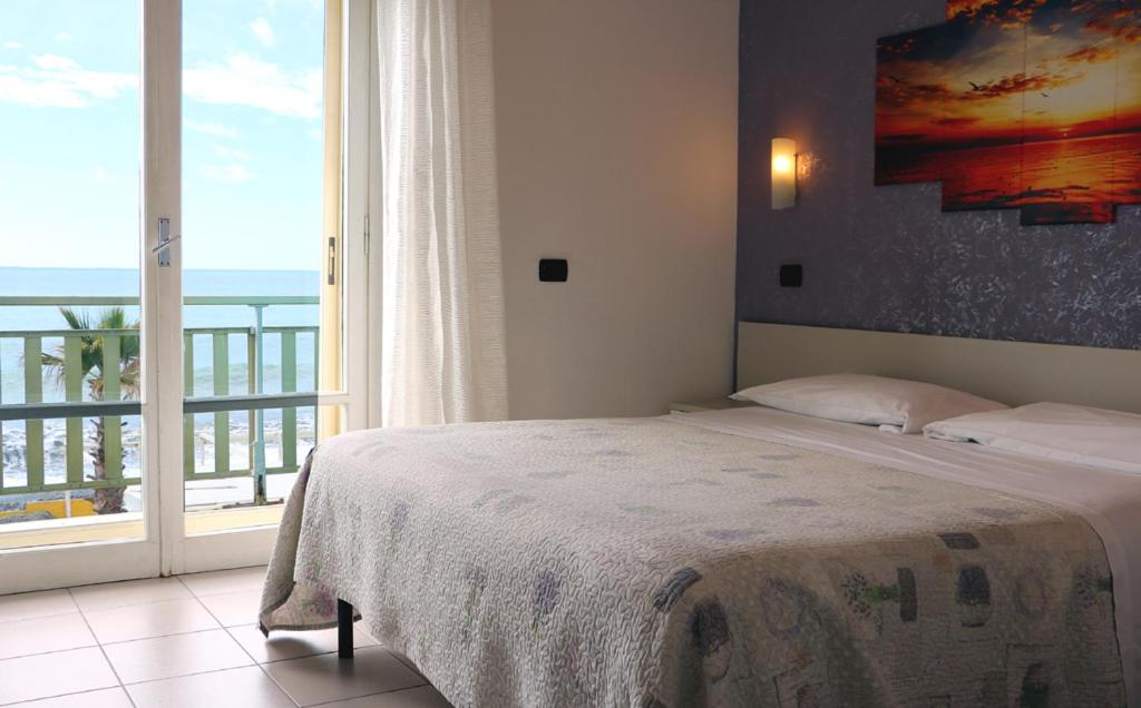 une chambre avec un lit et une grande fenêtre dans l'établissement Hotel Piccolo Paradiso, à Bordighera