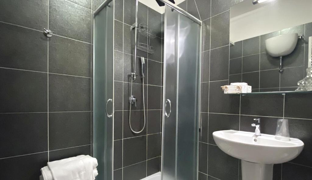 une salle de bain avec douche et lavabo dans l'établissement Hotel Piccolo Paradiso, à Bordighera