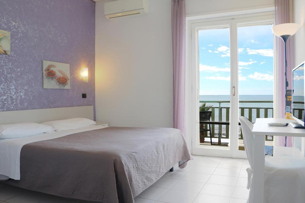 une chambre avec un lit et une vue sur l'océan dans l'établissement Hotel Piccolo Paradiso, à Bordighera