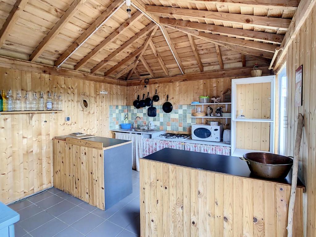 une cuisine avec des murs en bois et un comptoir noir dans l'établissement Anouchka Ô fil 2 l'eau, yourte en bord de Lac, à Saint-Maurice-sur-Loire
