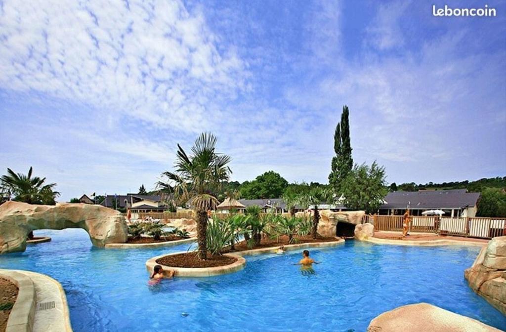 - une piscine dans un complexe avec des personnes qui s'y baignent dans l'établissement Le beau mobilhome, à Deauville