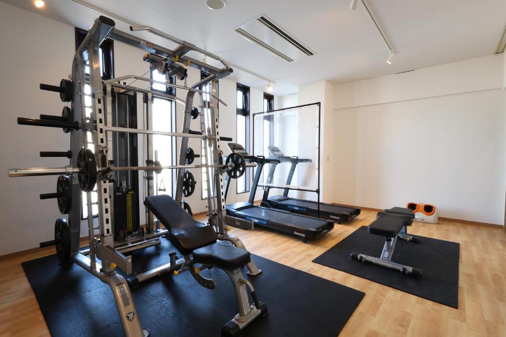 une salle de sport avec plusieurs machines à bande de roulement et poids dans l'établissement Kojohama Onsen Hotel, à Shiraoi