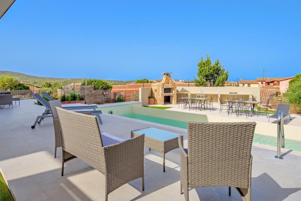 une terrasse avec des chaises, une table et une piscine dans l'établissement Villa Mirtillo Golfo Aranci, à Golfo Aranci