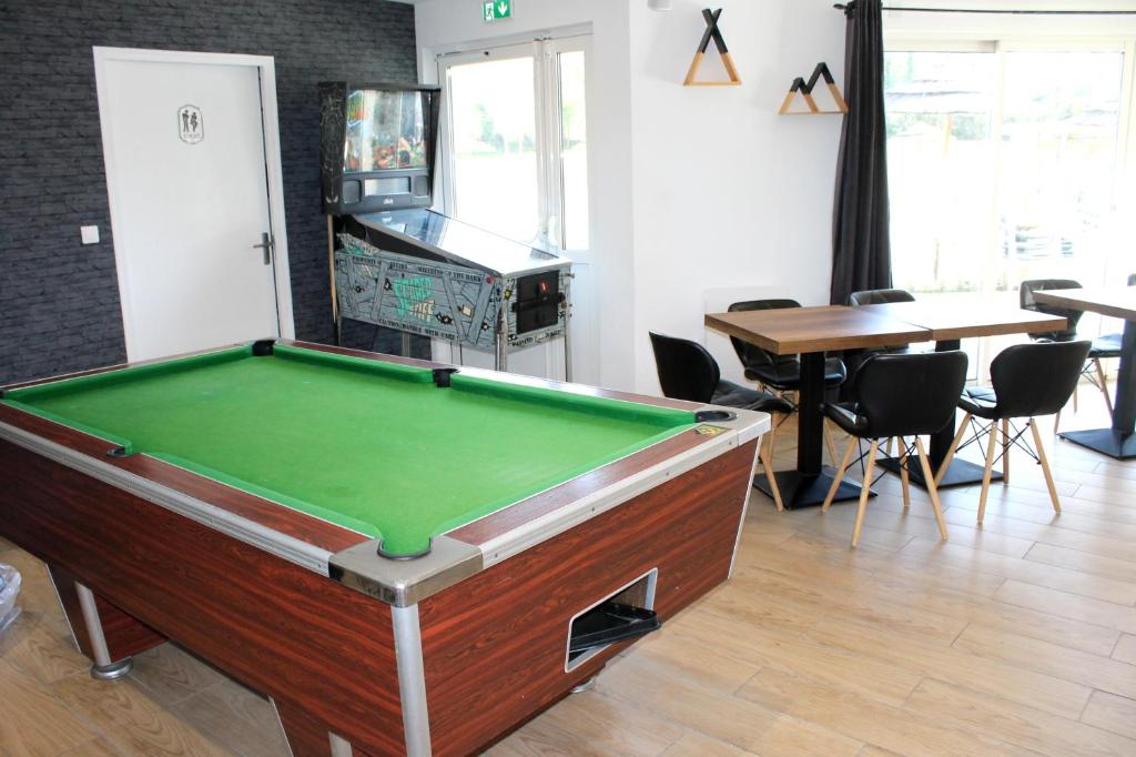 - un billard dans une pièce avec une table et des chaises dans l'établissement Mobil Home XXL 4 chambres - Camping du Quinquis, à Clohars-Carnoët