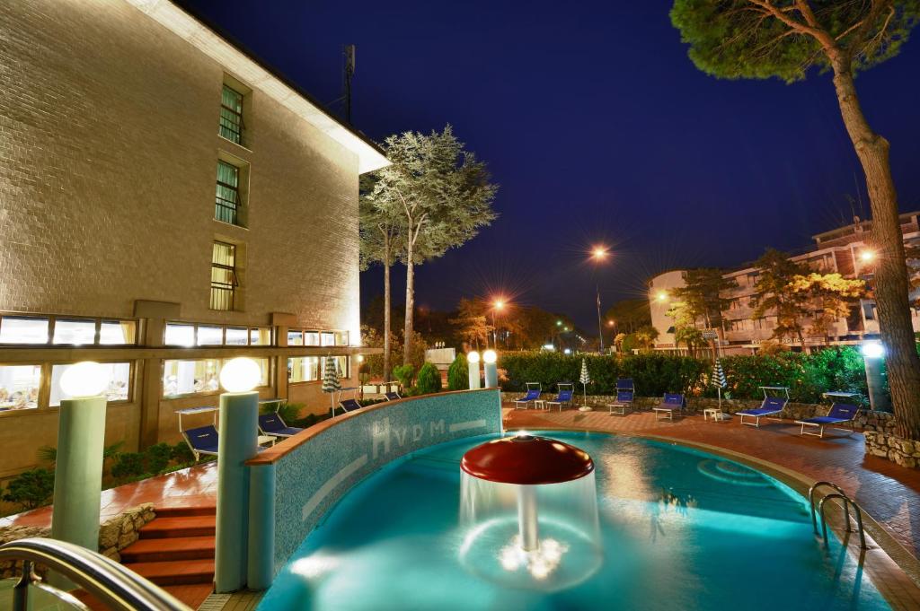une piscine devant un immeuble la nuit dans l'établissement Hotel Vina De Mar, à Lignano Sabbiadoro
