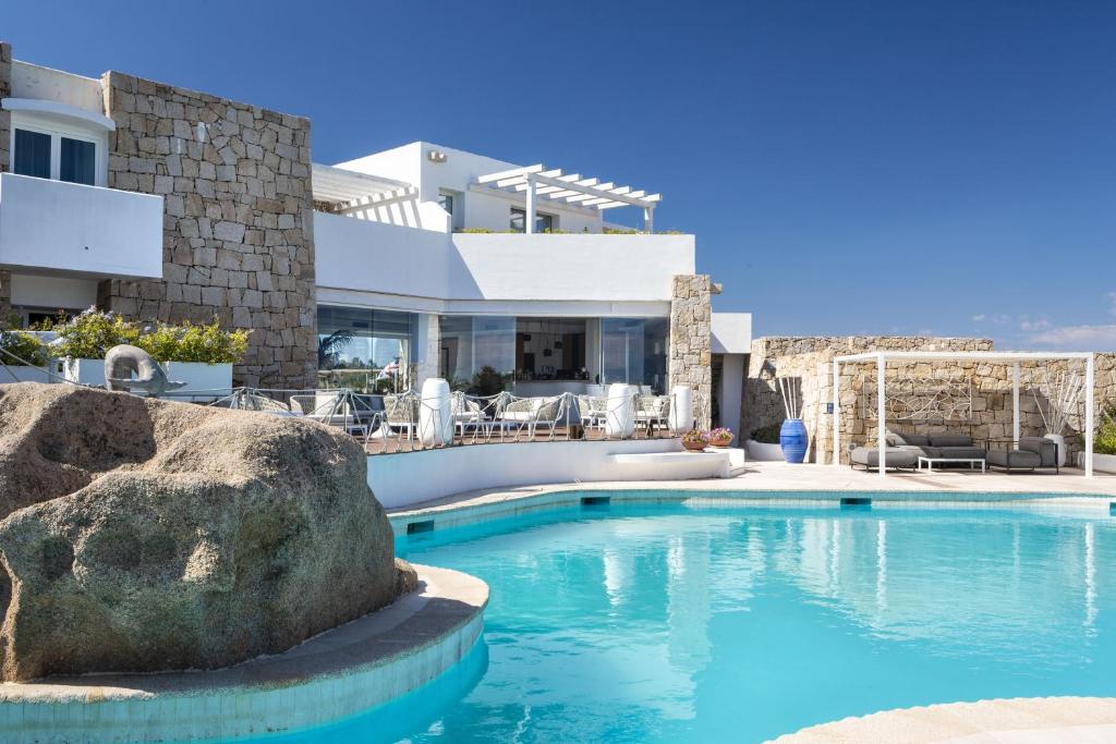 une piscine devant une maison dans l'établissement Hotel Grand Relais Dei Nuraghi, à Baja Sardinia