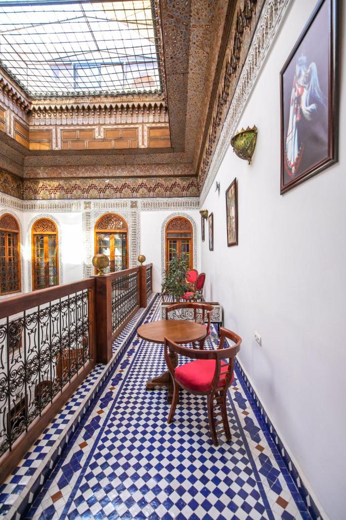 une pièce avec une table et des chaises sur un balcon dans l'établissement Riad Jamal, à Fès
