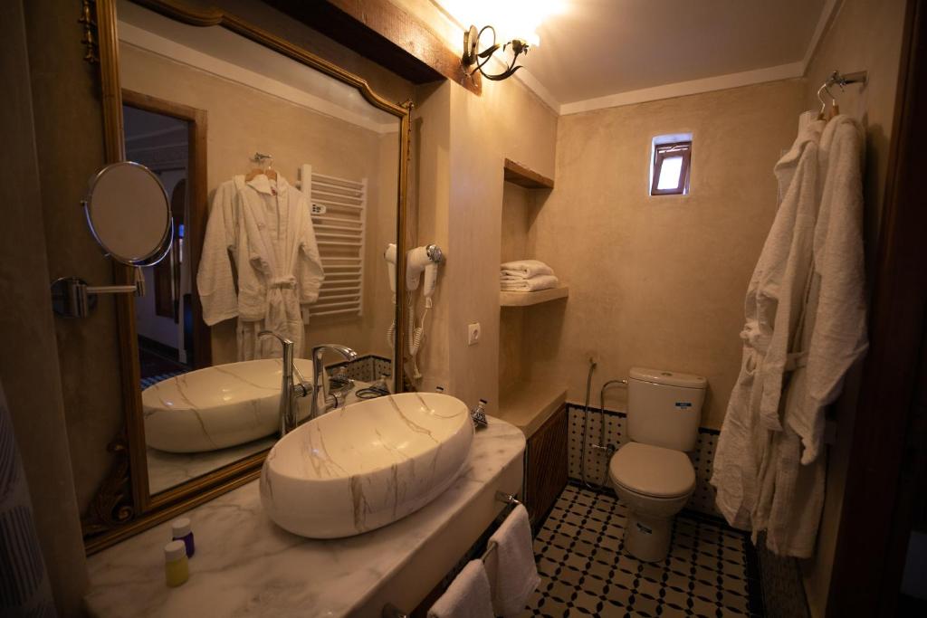 une salle de bain avec un lavabo, des toilettes et un miroir dans l'établissement Riad Jamal, à Fès 37 autres photos