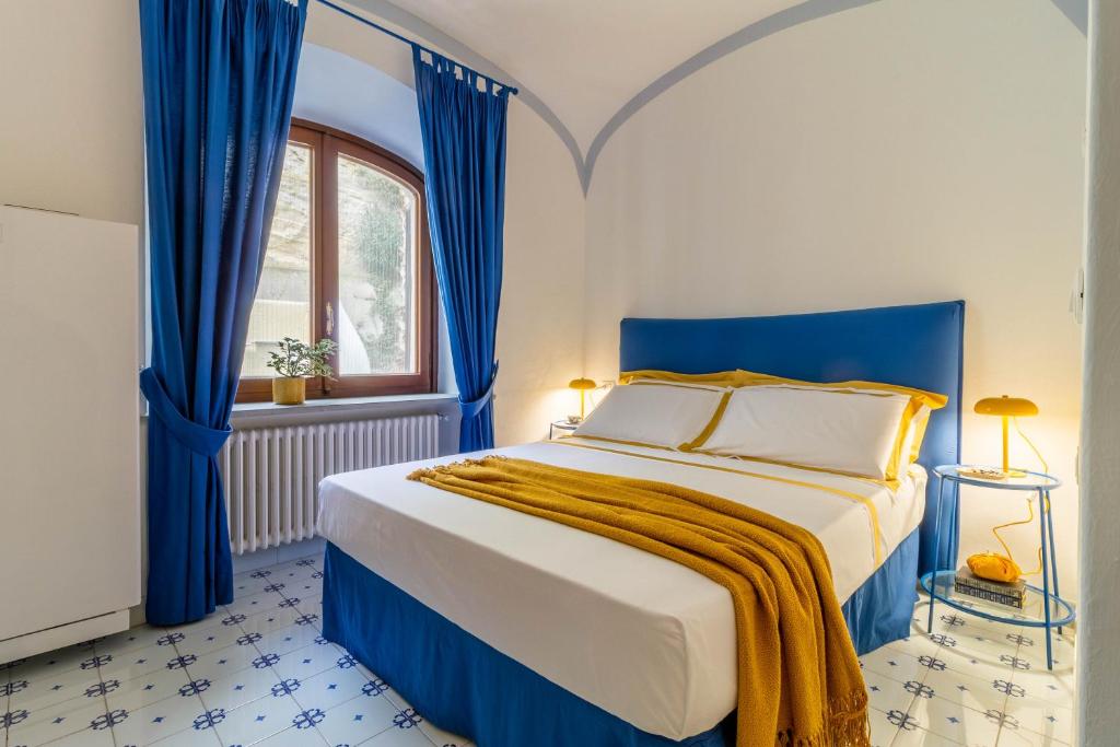 - une chambre bleue et blanche avec un lit et une fenêtre dans l'établissement Villa Le Pagine Bianche, à Ischia