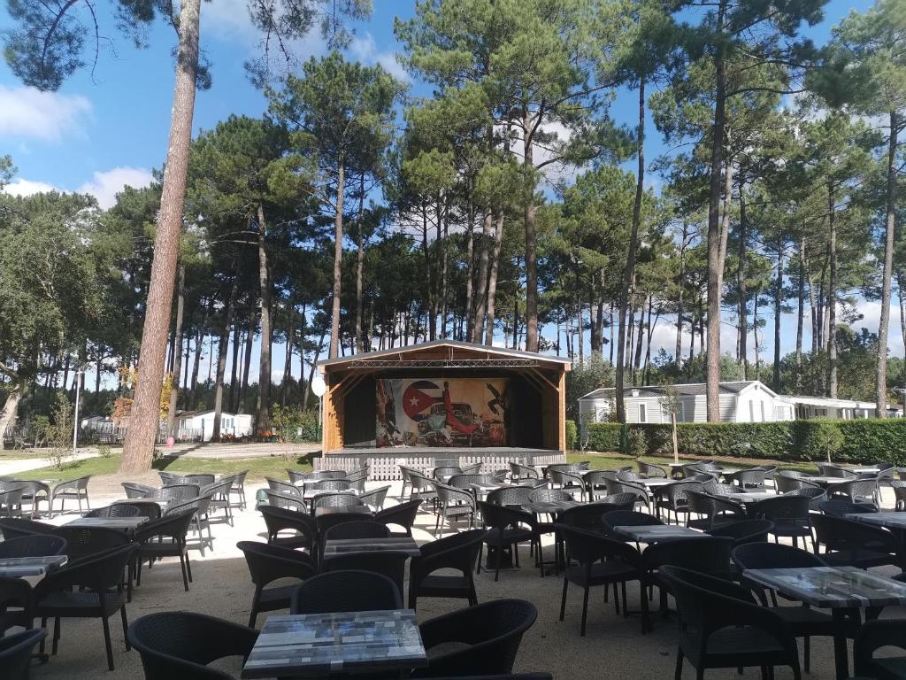 un restaurant vide avec des tables et des chaises dans un parc dans l'établissement Le Soleil Mobil-home, à Saint-Julien-en-Born