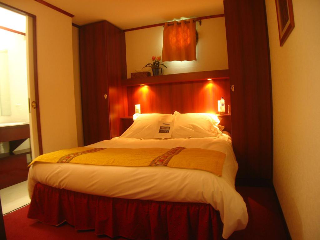une chambre avec un grand lit dans une pièce dans l'établissement Bateau Le Phénicien, à Aigues-Mortes