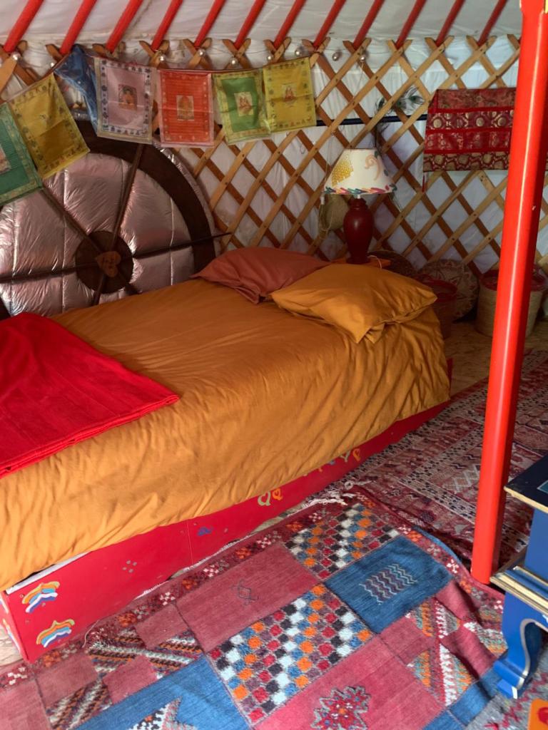 - un lit dans une yourte avec une couette dans l'établissement la yourte du moulin, à Champrond