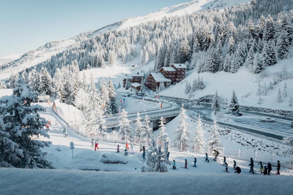 un groupe de personnes debout sur une montagne enneigée dans l'établissement Hôtel Alpen Ruitor, à Méribel