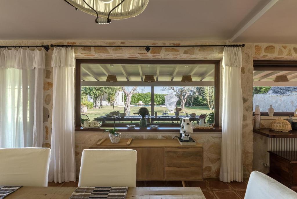 une cuisine avec une fenêtre, une table et des chaises dans l'établissement Villa Enò by Perle di Puglia, à Noci