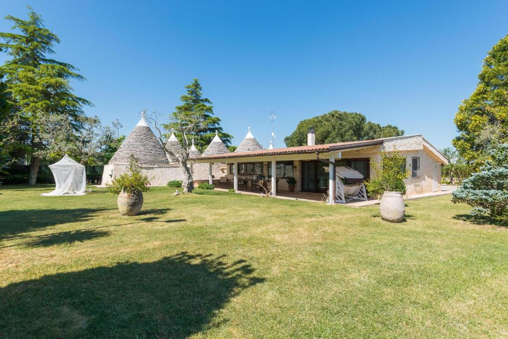 une maison avec une grande cour et une maison dans l'établissement Villa Enò by Perle di Puglia, à Noci